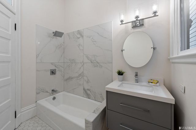 a bathroom with a sink vanity tub and a mirror