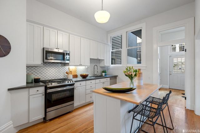 a kitchen with a stove cabinets and wooden floor