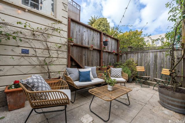 a backyard of a house with barbeque oven table and chairs