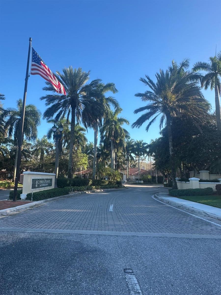 6920 West Sample Road, Unit 6920 Pompano Beach, FL 33063 - Photo 2 of 30 a palm tree sitting on a sidewalk next to a building