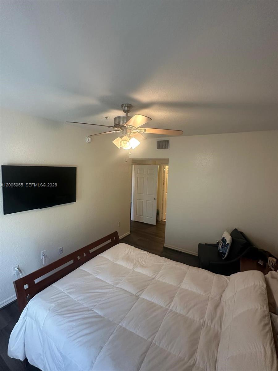 6920 West Sample Road, Unit 6920 Pompano Beach, FL 33063 - Photo 7 of 30 a bedroom with a bed and a ceiling fan