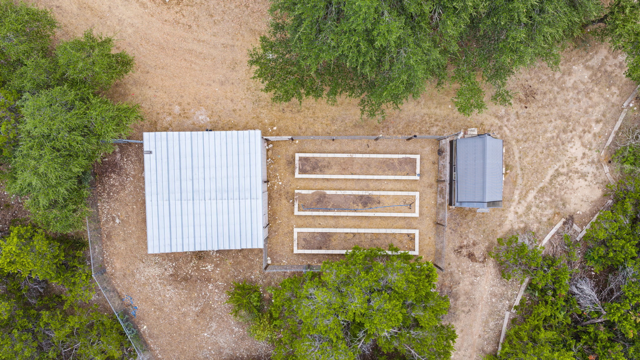 24 Long Creek Road Austin, TX 78737 - Photo 32 of 36 Aerial view of storage barn, raised garden, and green house.