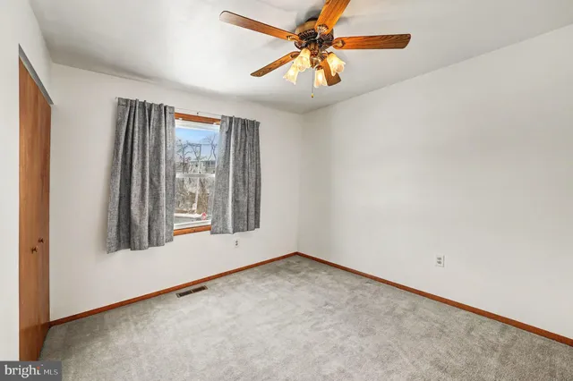 an empty room with a ceiling fan and fan