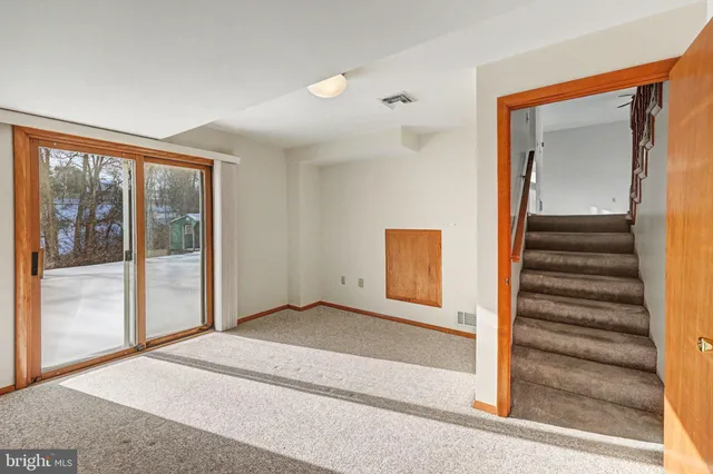 a view of an empty room with a fireplace and a window