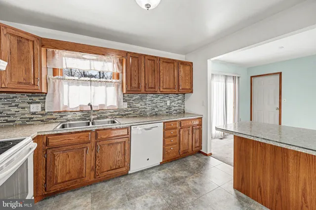 a kitchen with granite countertop a sink stove and cabinets