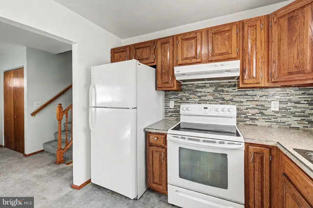a kitchen with a stove top oven and refrigerator