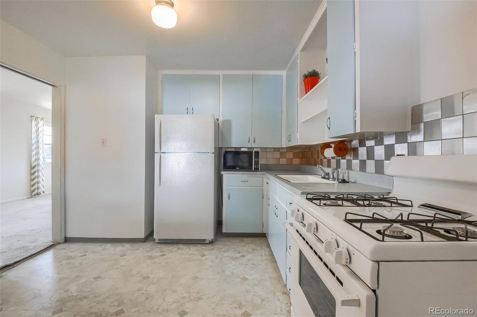 8941 Lilly Drive Thornton, CO 80229 - Photo 11 of 27 a kitchen with a stove a refrigerator and a sink
