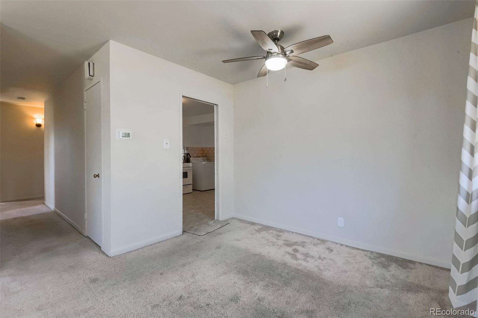 8941 Lilly Drive Thornton, CO 80229 - Photo 12 of 27 an empty room with a ceiling fan and a window