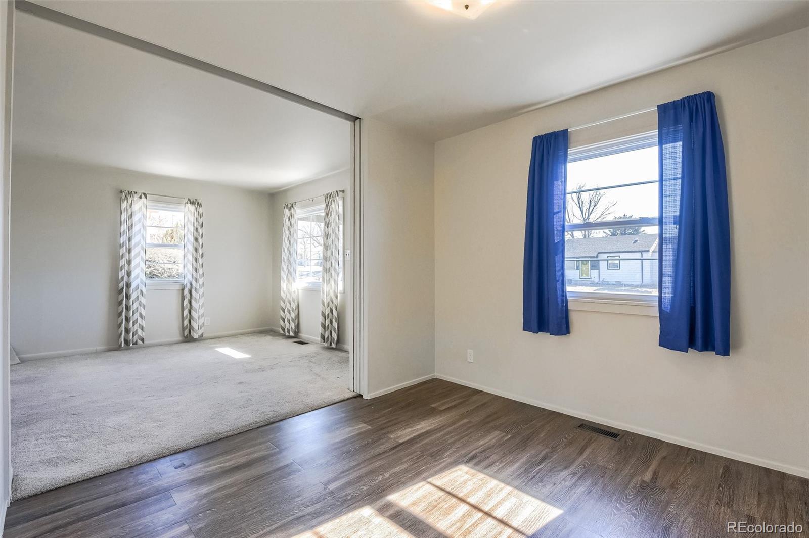 8941 Lilly Drive Thornton, CO 80229 - Photo 17 of 27 a view of an empty room with wooden floor and a window