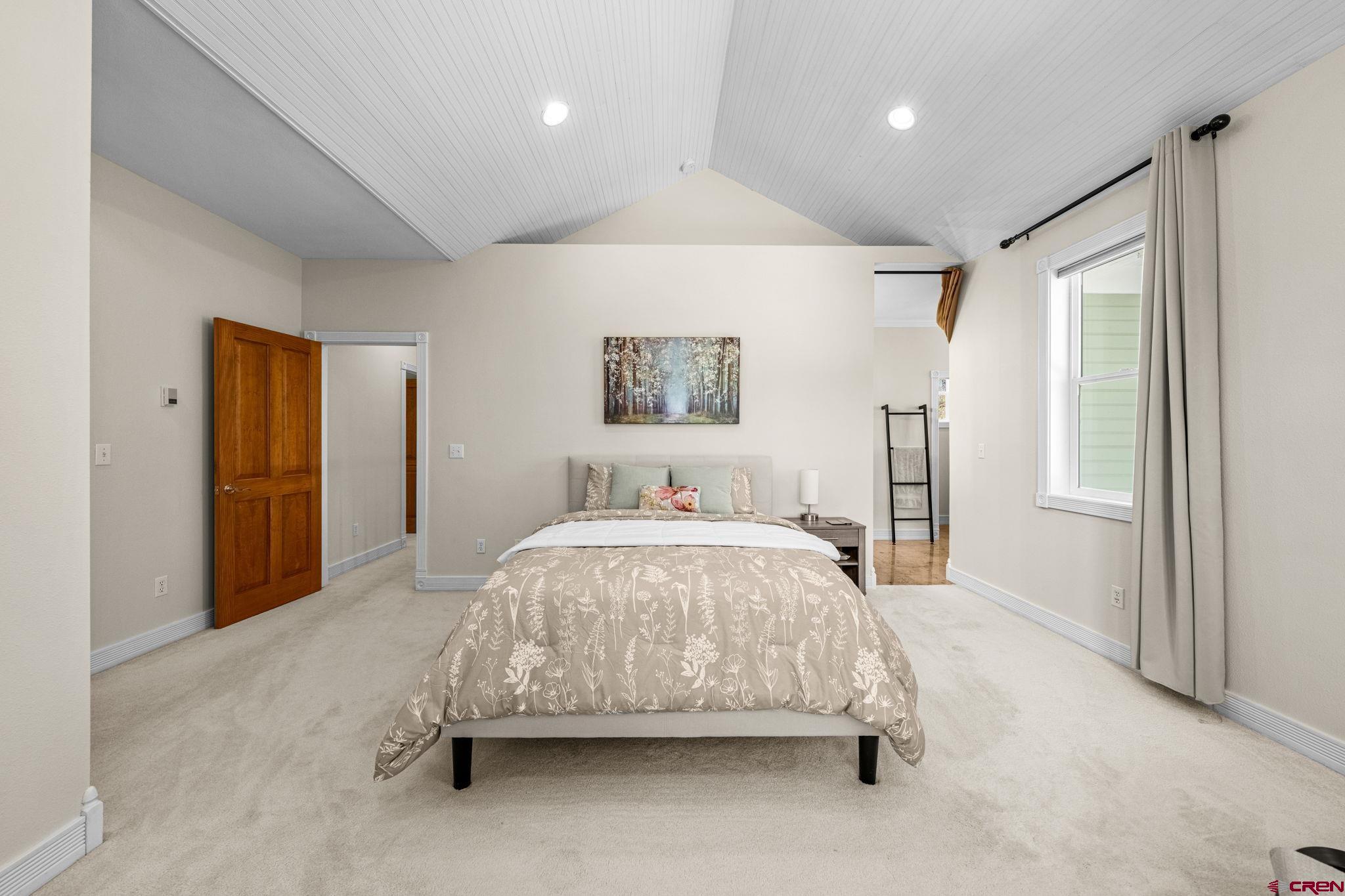 823 The Eagle Pass Durango, CO 81301 - Photo 24 of 42 a spacious bedroom with a bed and a painting