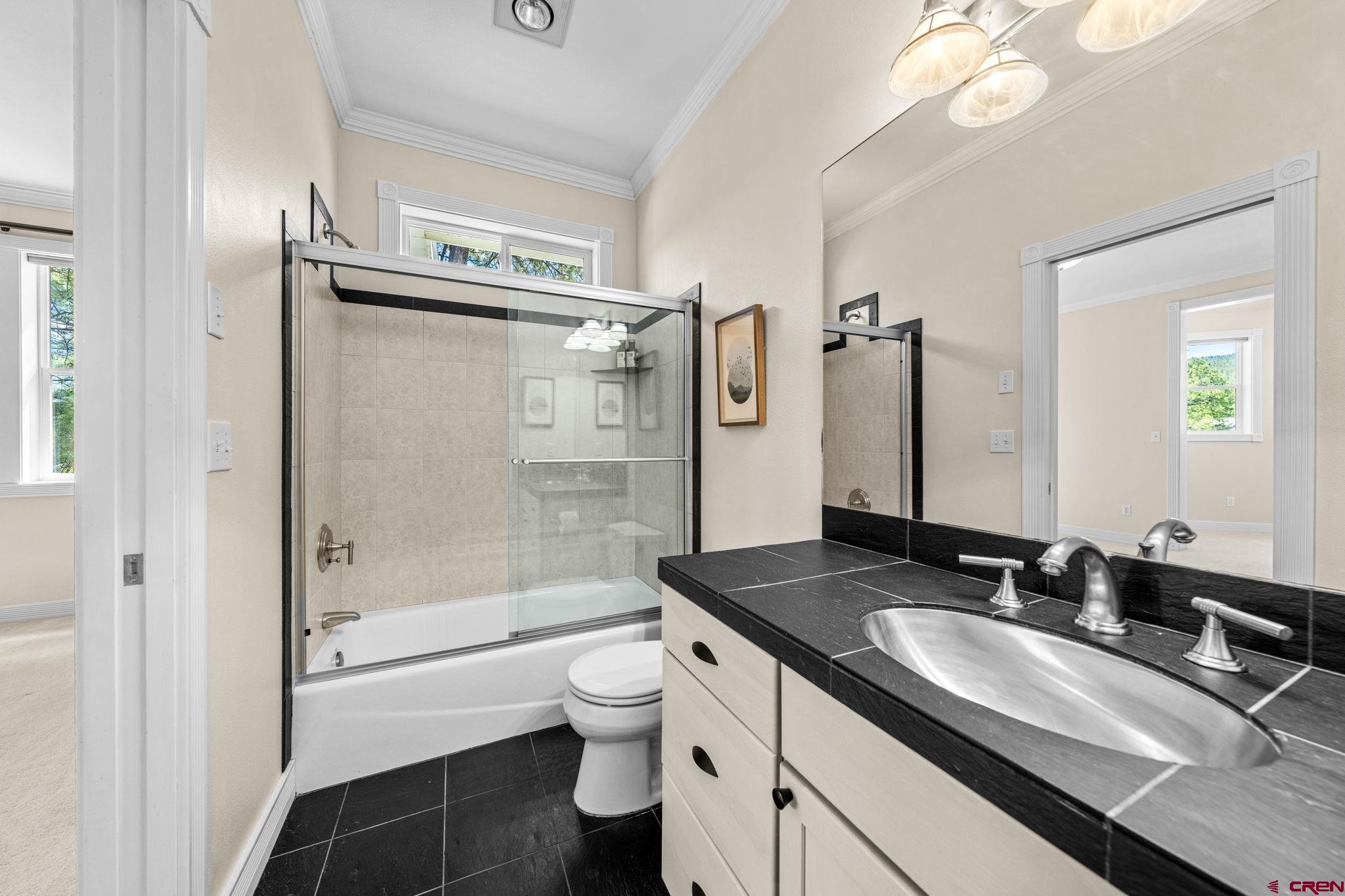 823 The Eagle Pass Durango, CO 81301 - Photo 32 of 42 a bathroom with a granite countertop sink a toilet a mirror and shower