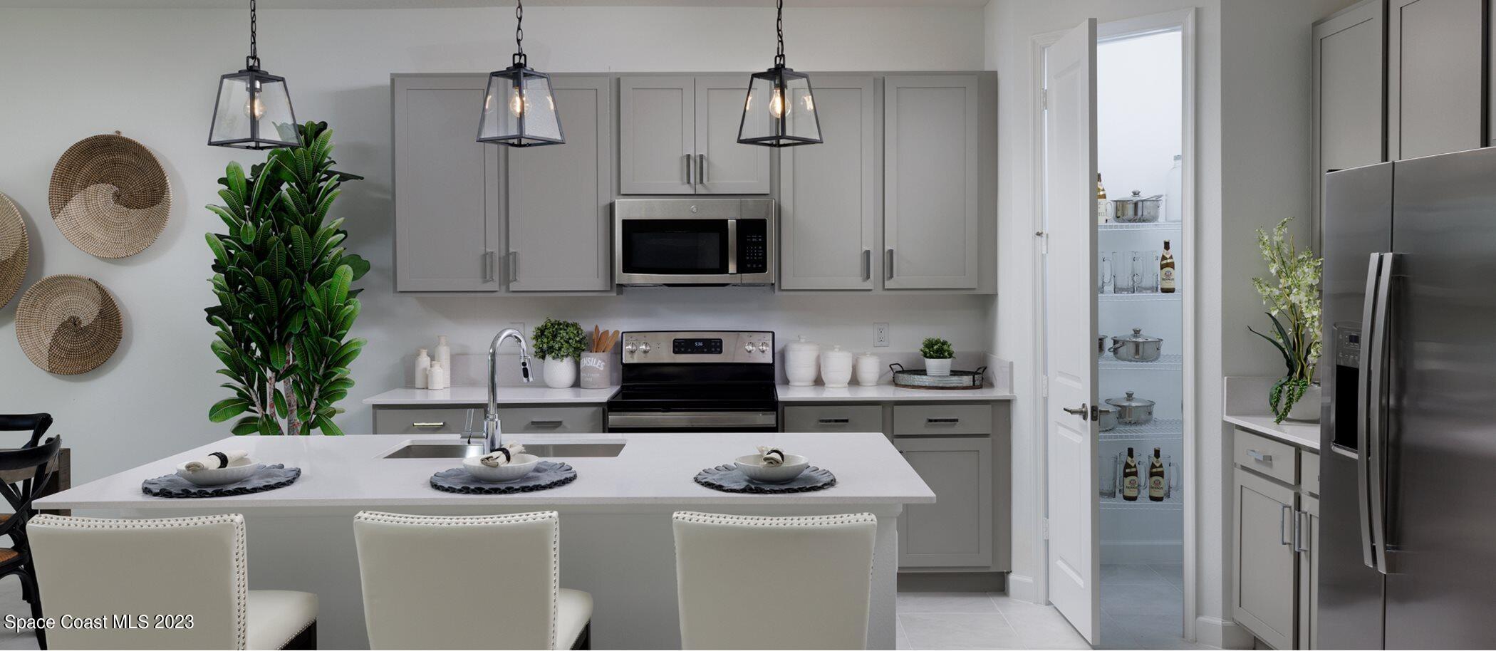 724 Veridian Circle Northwest Palm Bay, FL 32907 - Photo 2 of 10 a kitchen with stainless steel appliances kitchen island a refrigerator and a sink