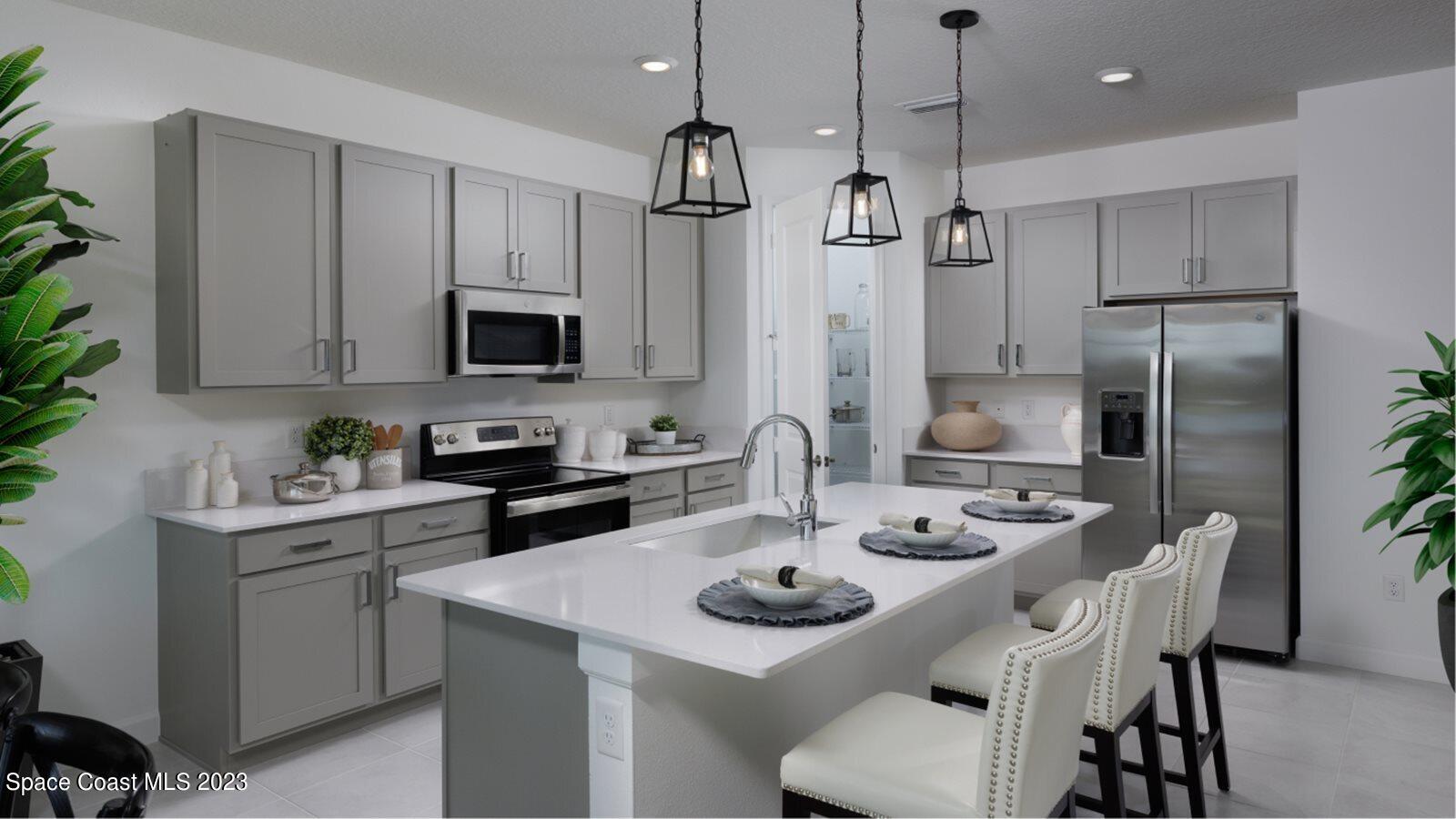 724 Veridian Circle Northwest Palm Bay, FL 32907 - Photo 3 of 10 a kitchen with refrigerator cabinets dining table and chairs