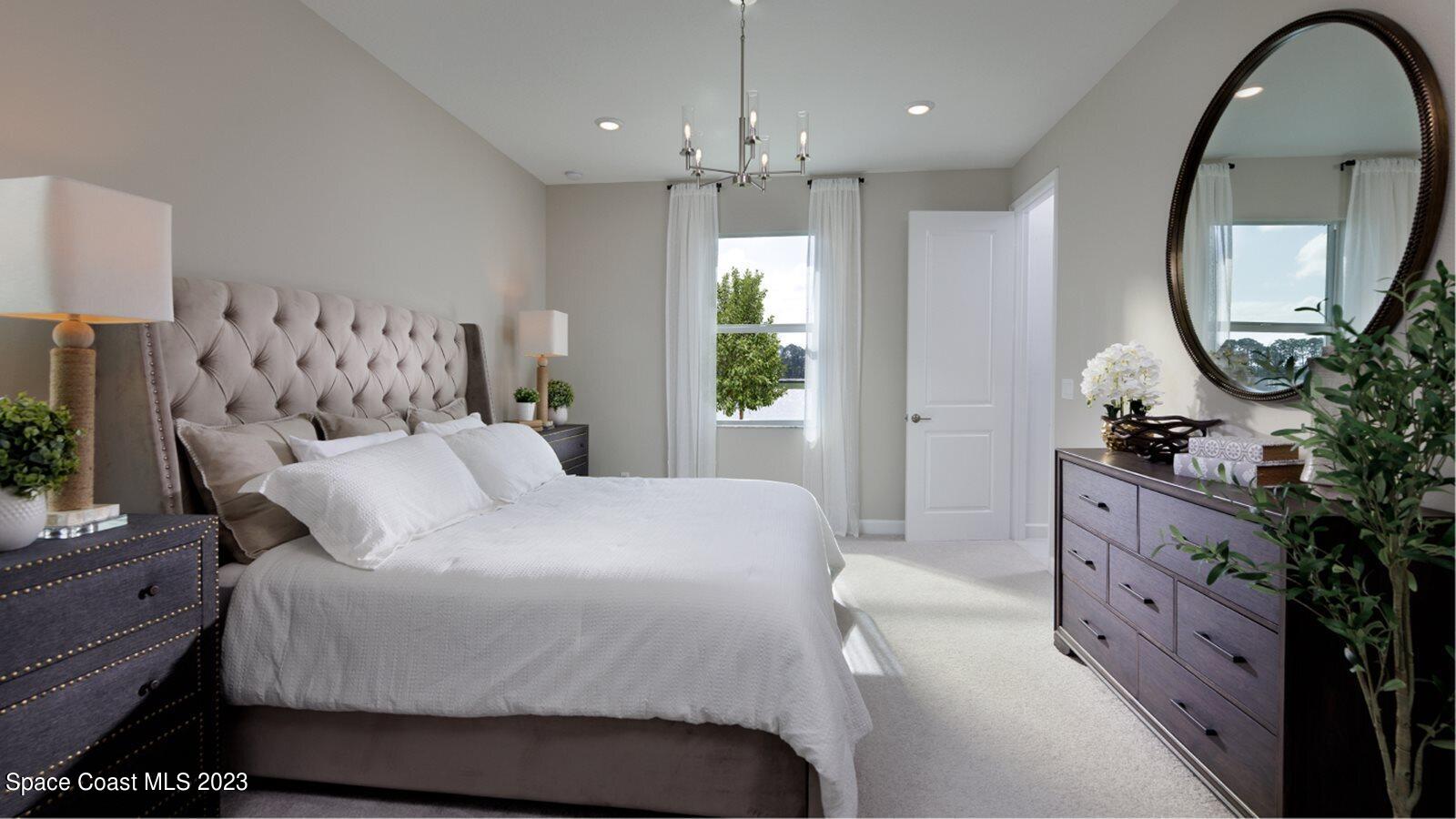 724 Veridian Circle Northwest Palm Bay, FL 32907 - Photo 6 of 10 a bedroom with a large bed and a chandelier