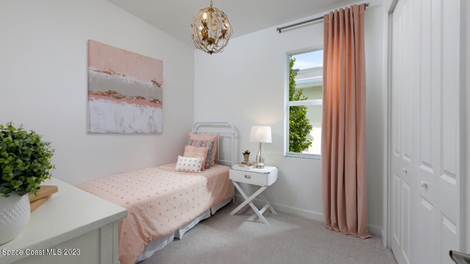 724 Veridian Circle Northwest Palm Bay, FL 32907 - Photo 8 of 10 a bedroom with a bed and a chandelier