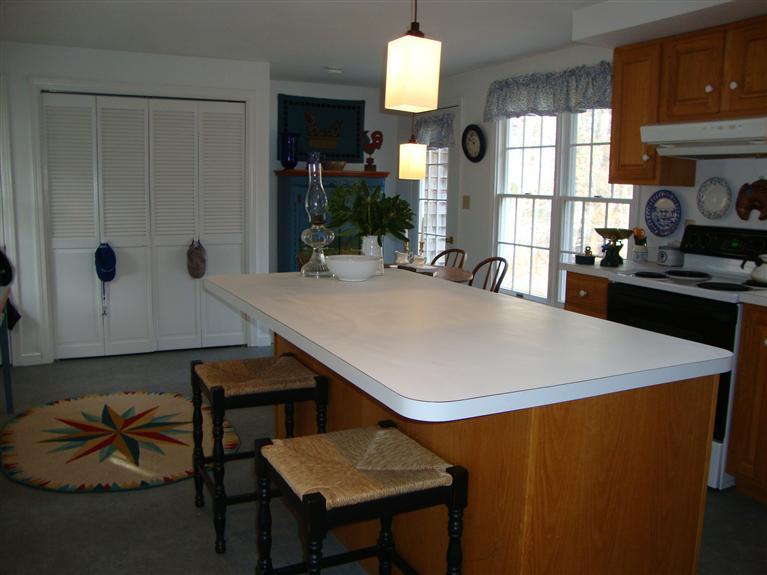 181 Northgate Road North Chatham, MA 02633 - Photo 8 of 20 a kitchen with stainless steel appliances a table chairs and a refrigerator