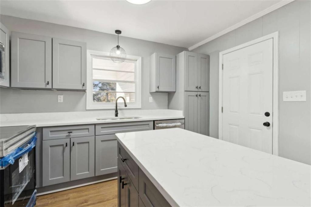 269 Elks Street Winder, GA 30680 - Photo 18 of 42 a kitchen with stainless steel appliances granite countertop a sink dishwasher a refrigerator and white cabinets with wooden floor