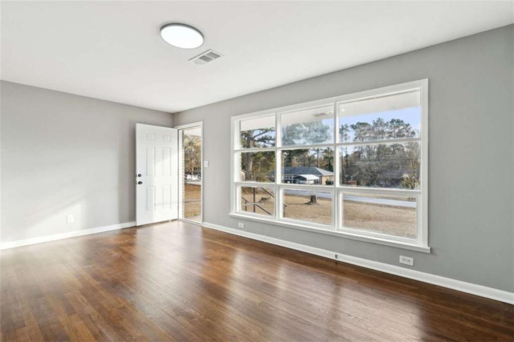 269 Elks Street Winder, GA 30680 - Photo 7 of 42 a view of an empty room with wooden floor and a window