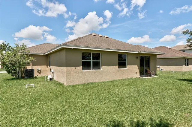 a sign that is sitting in front of a house with a garden