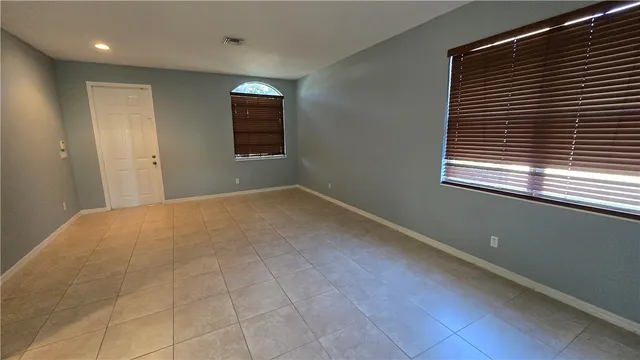 en empty room with windows and fan