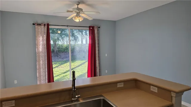 a view of empty room with a window and ceiling fan