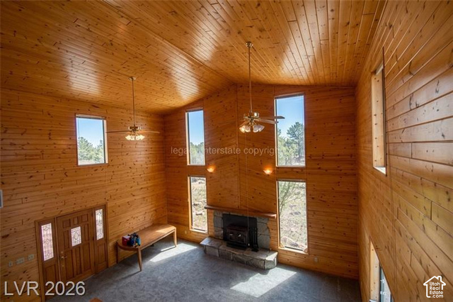 1129 Ponderosa Road, Unit 40 Hatch, UT 84735 - Photo 8 of 47 Vaulted wood-paneled ceilings, wood-paneled walls, stone fireplace with hearth, multiple windows, and a wood entry door with glass inserts