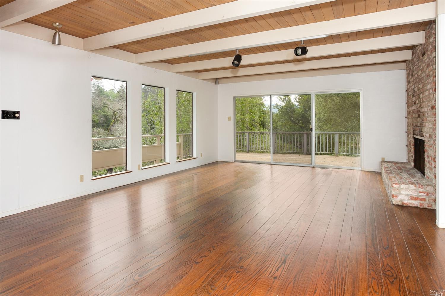 a view of wooden floor and windows in a room
