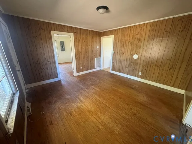 a view of an empty room with wooden floor