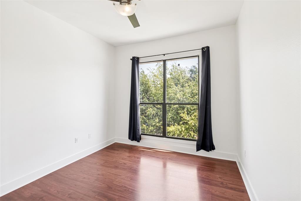 4414 Cedar Springs Road, Unit 320 Dallas, TX 75219 - Photo 12 of 17 an empty room with wooden floor and windows