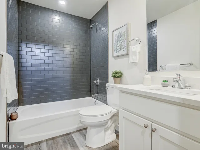 a bathroom with a bathtub shower sink vanity and a toilet