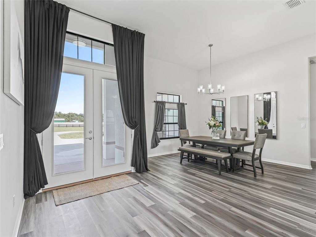 7041 Northeast 22nd Ct Road Ocala, FL 34479 - Photo 18 of 73 a view of a dining room with furniture window and wooden floor