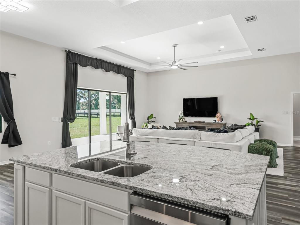 7041 Northeast 22nd Ct Road Ocala, FL 34479 - Photo 29 of 73 a kitchen with sink microwave and view living room