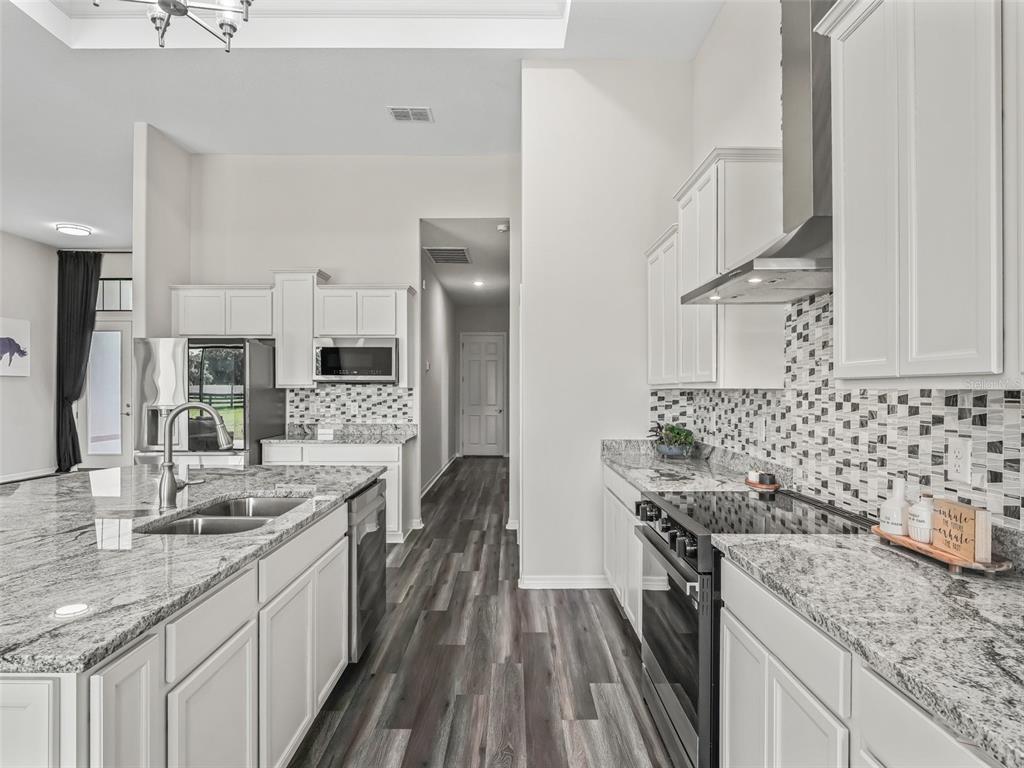 7041 Northeast 22nd Ct Road Ocala, FL 34479 - Photo 34 of 73 a kitchen with stainless steel appliances granite countertop a sink stove and refrigerator
