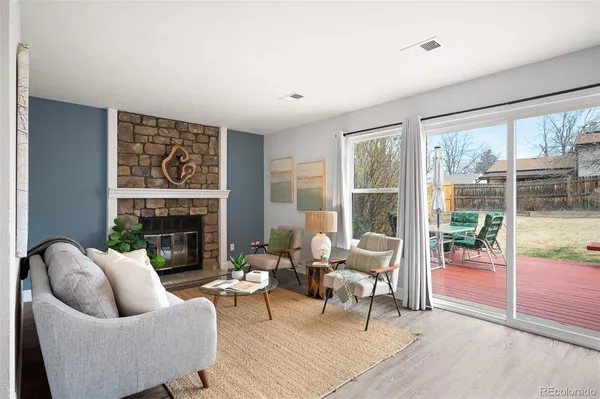 a living room with furniture a large window and a fireplace