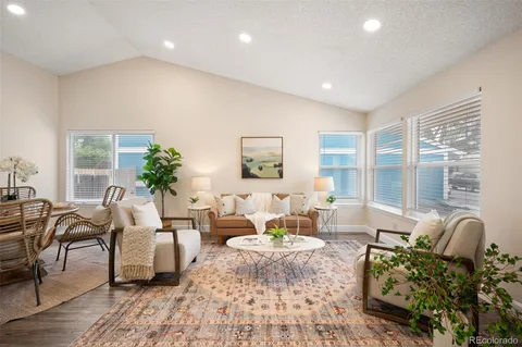 a living room with furniture potted plant and a large window