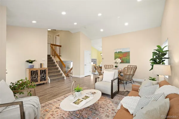 a living room with furniture kitchen view and a wooden floor