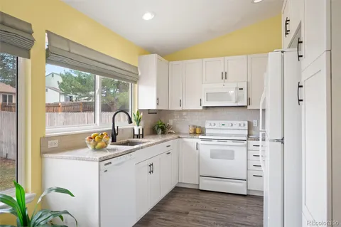 a kitchen with white cabinets and white appliances