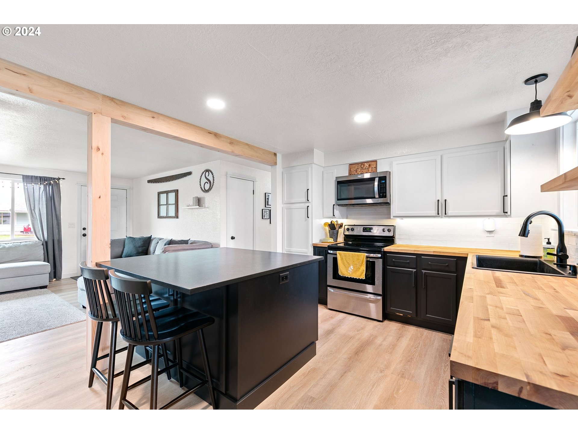 3734 Cherokee Drive Springfield, OR 97478 - Photo 16 of 39 a kitchen with stainless steel appliances granite countertop a sink dishwasher a stove a refrigerator a dining table and chairs with wooden floor