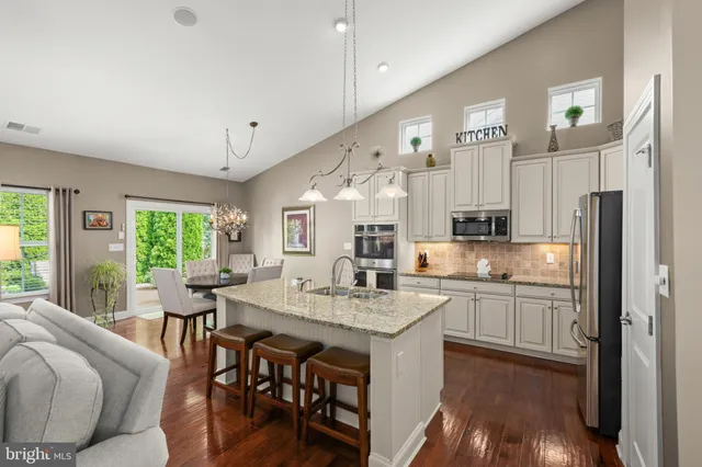 a kitchen with granite countertop a sink appliances cabinets and furniture