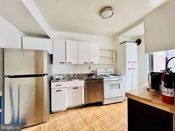 a kitchen with a refrigerator a stove and a sink