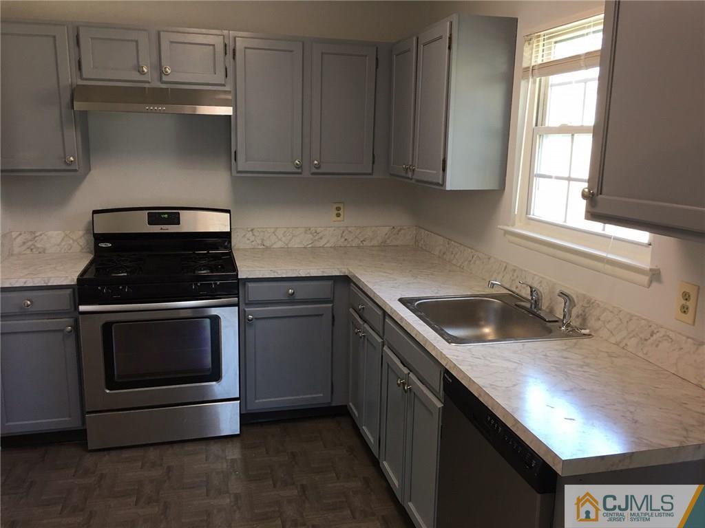 22 Woodbury Road Edison, NJ 08820 - Photo 12 of 25 a kitchen with granite countertop a stove sink and cabinets