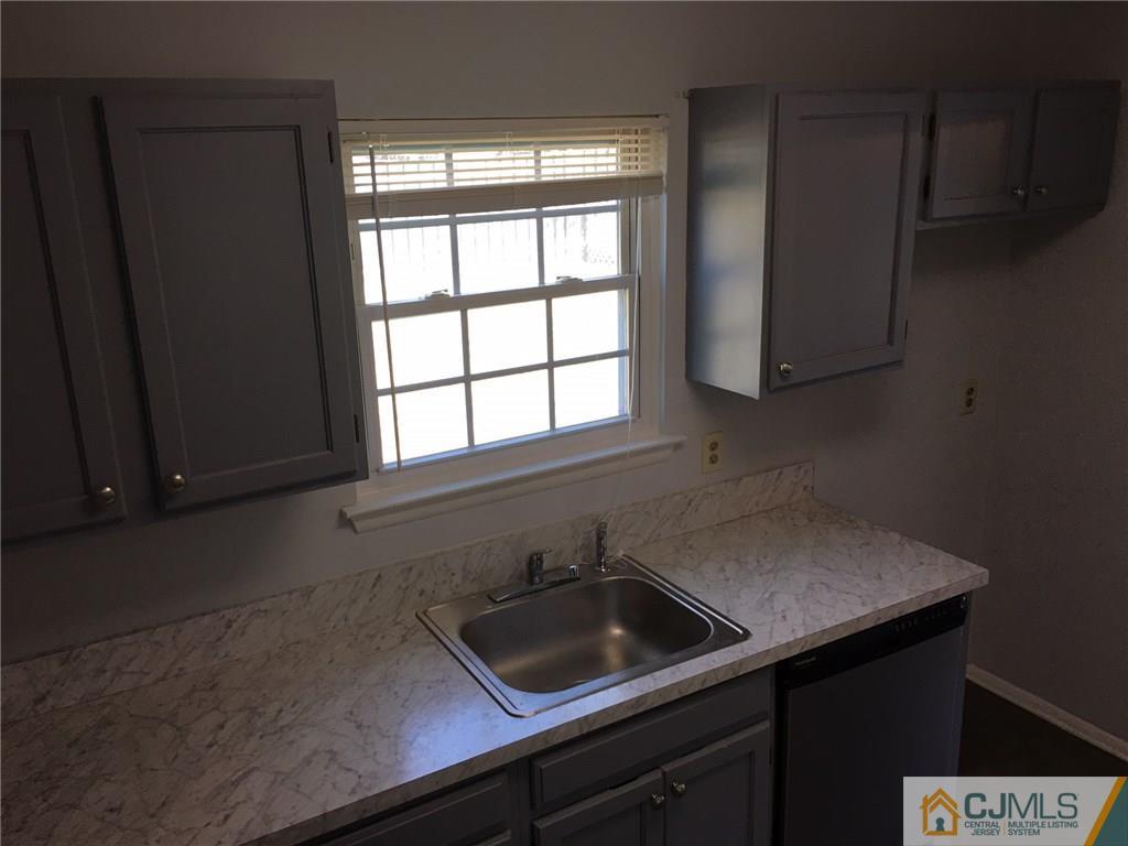 22 Woodbury Road Edison, NJ 08820 - Photo 14 of 25 a view of a sink a microwave and window in a kitchen
