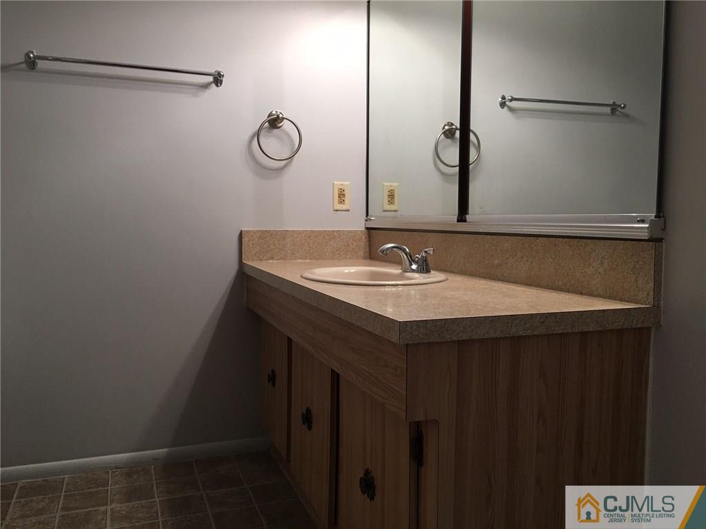 22 Woodbury Road Edison, NJ 08820 - Photo 18 of 25 a bathroom with a sink vanity and a mirror