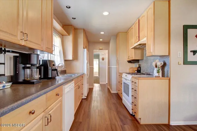 a large kitchen with stainless steel appliances lots of counter space and wooden floor