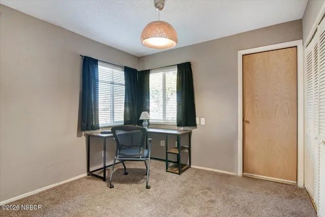 a view of a workspace with furniture and a window
