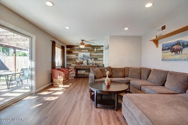 a living room with furniture and a wooden floor