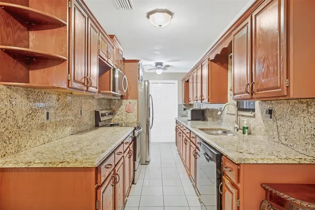 a kitchen with stainless steel appliances granite countertop a sink and cabinets
