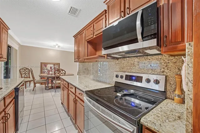 a kitchen with stainless steel appliances granite countertop a stove and a microwave
