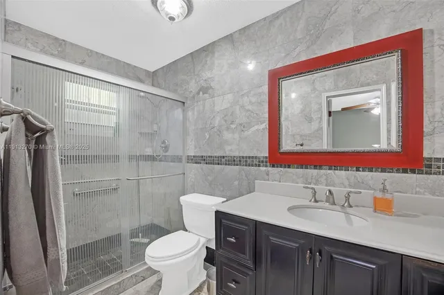 a bathroom with a sink toilet vanity and shower