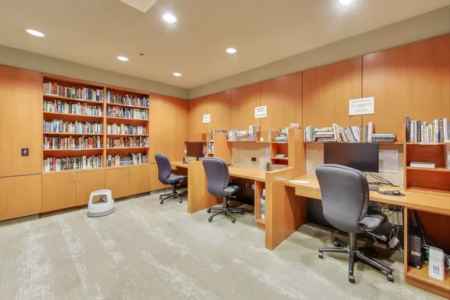 a view of a workspace with furniture and a window